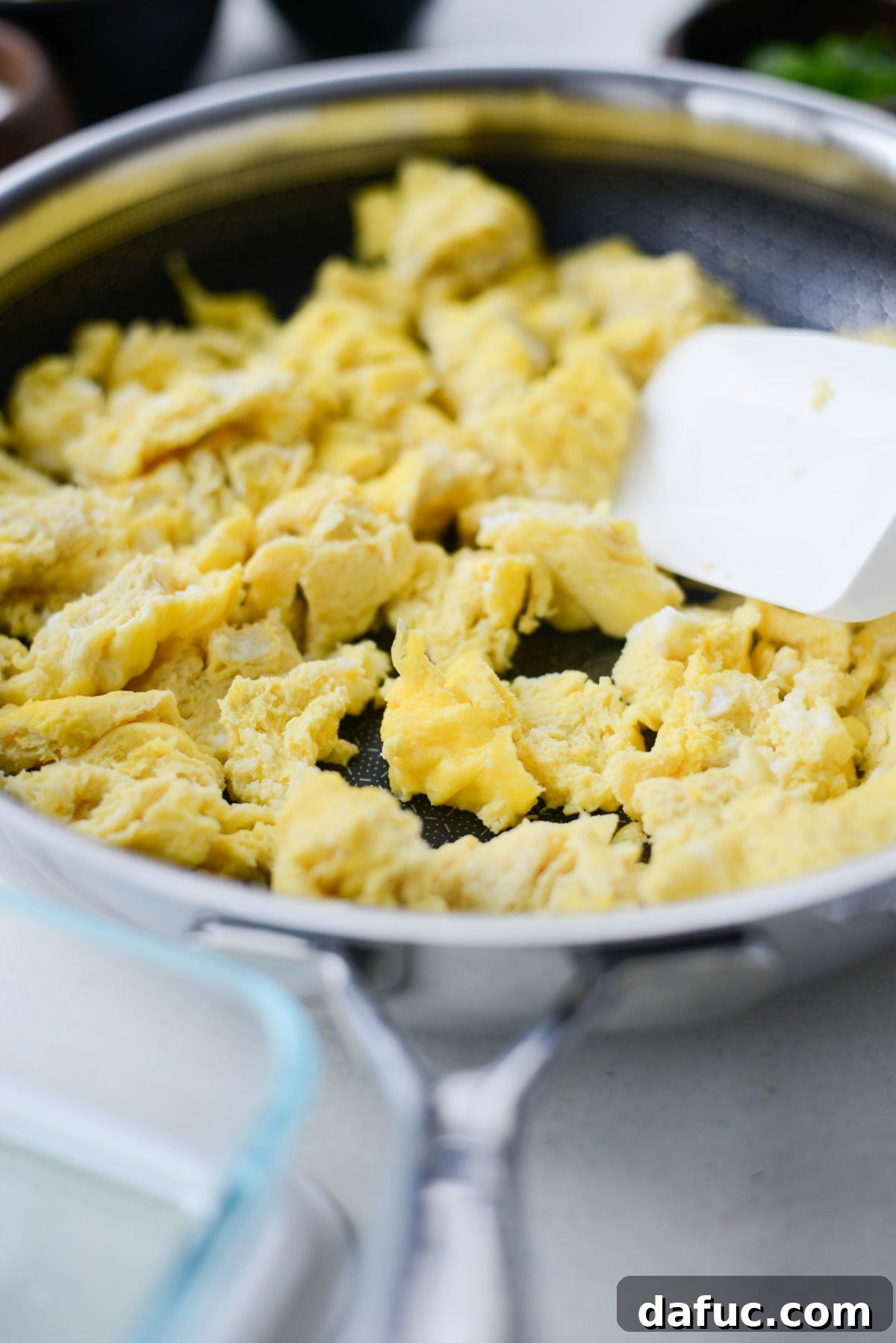 Easy Turkey Taco Breakfast Scramble Meal Prep 7 Close-up of light and fluffy scrambled eggs cooking in a non-stick skillet.