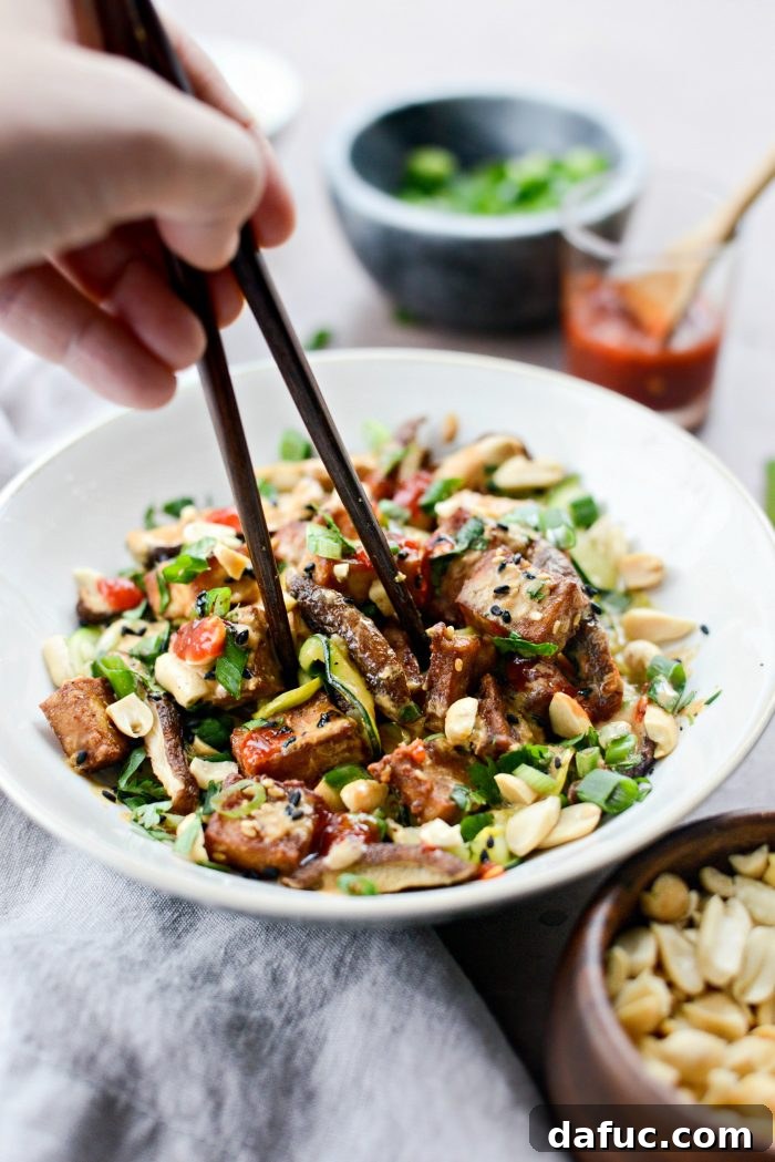 Perfectly Crispy Air Fryer Tofu with Creamy Peanut Sauce 15 Eating Crispy Peanut Tofu with Squash Noodles (Air Fryer) with chopsticks