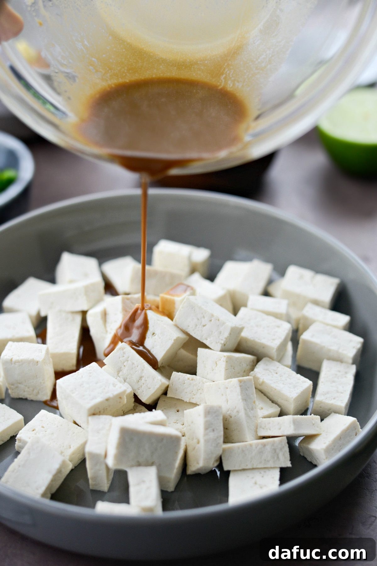 Perfectly Crispy Air Fryer Tofu with Creamy Peanut Sauce 6 Pouring marinade over tofu