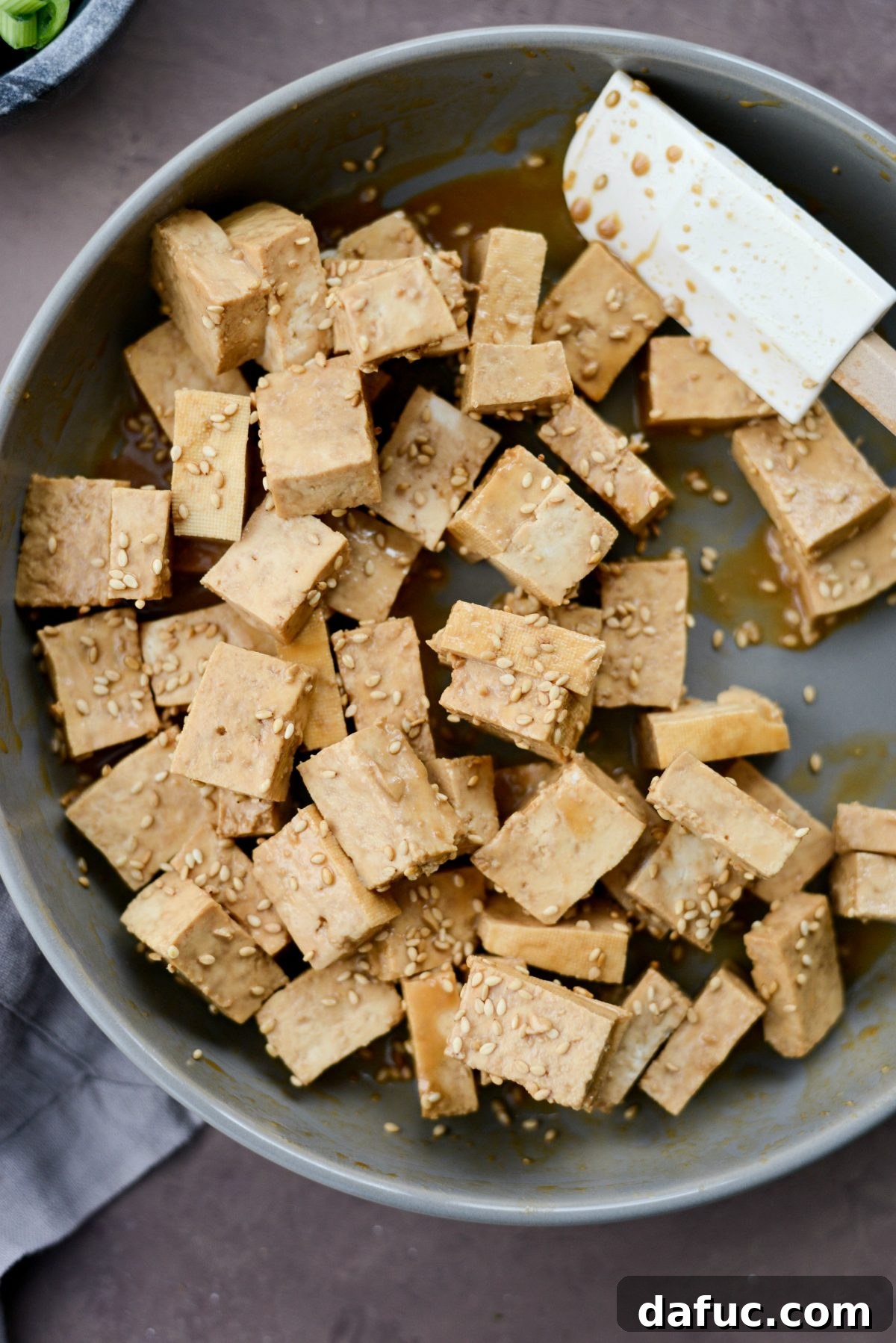 Perfectly Crispy Air Fryer Tofu with Creamy Peanut Sauce 7 Tofu coated in marinade and sesame seeds