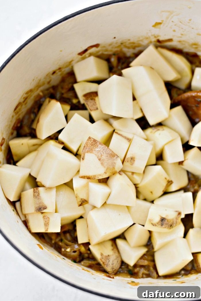 Creamy French Onion Chowder 12 Adding roughly peeled and chopped russet potatoes to the pot