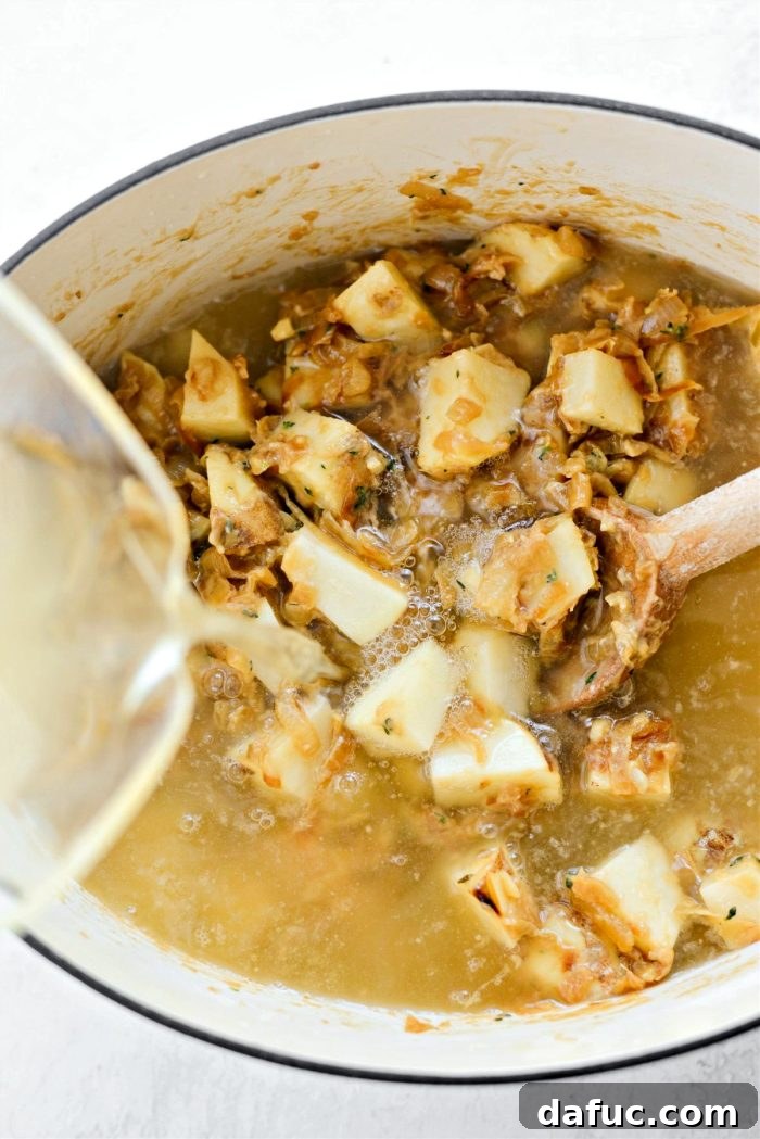 Creamy French Onion Chowder 15 Pouring low-sodium chicken broth into the pot