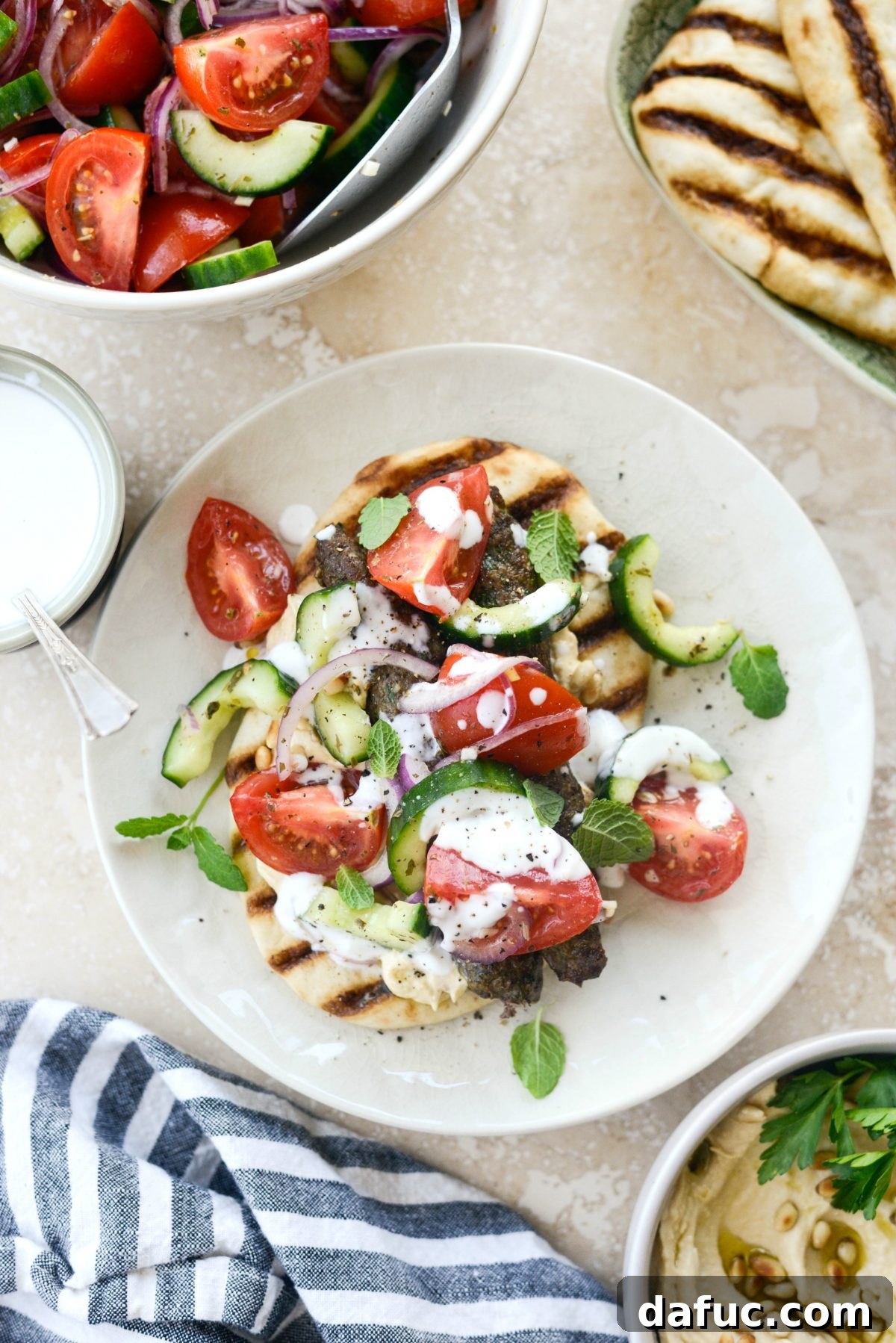 Artfully arranged Lamb Kofta Open-Faced Pita Sandwiches on a wooden board, ready for serving