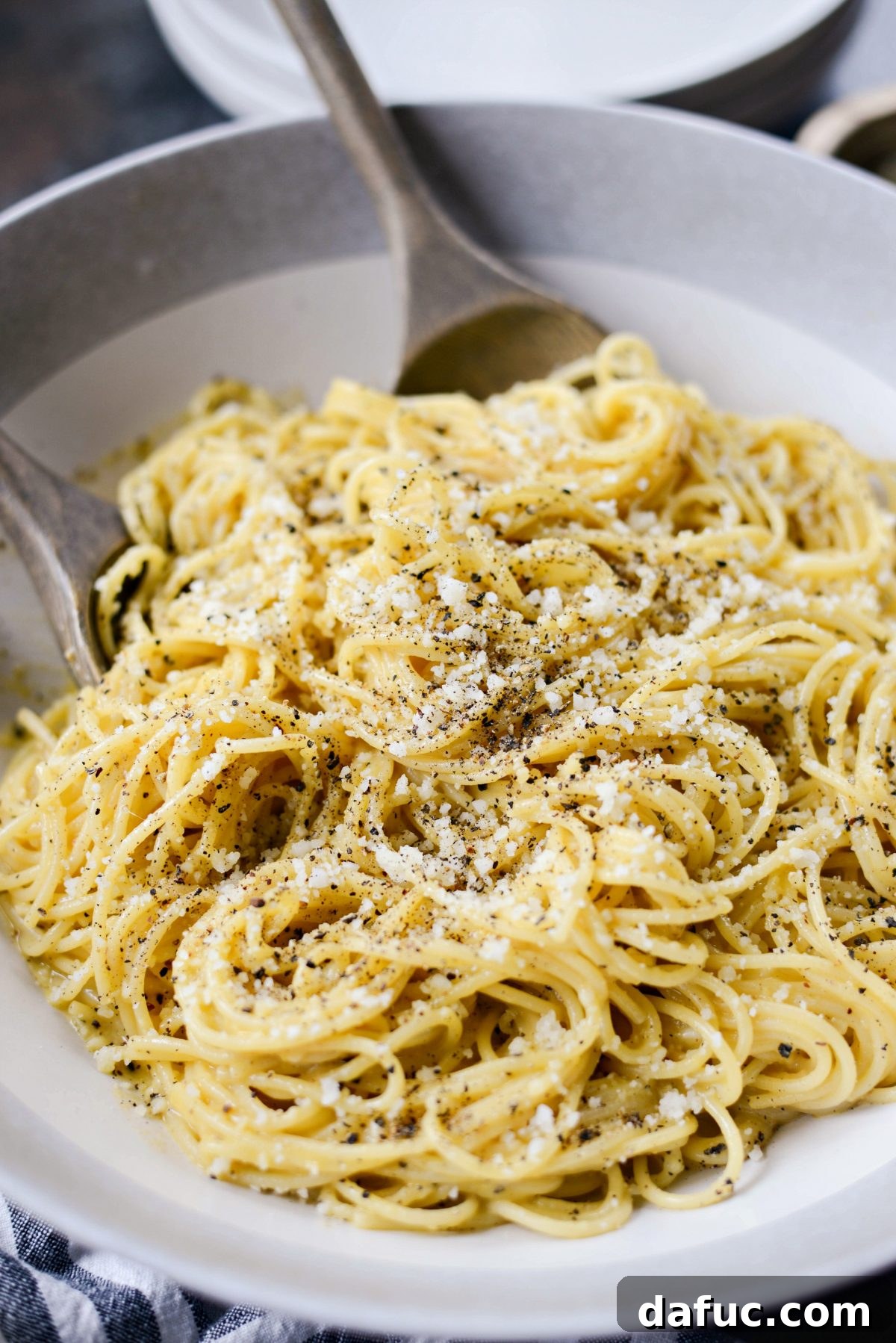 Reimagined Cacio e Pepe Carbonara 3 Cacio e Pepe Carbonara served in a large bowl with wooden serving spoons, showcasing its creamy texture.