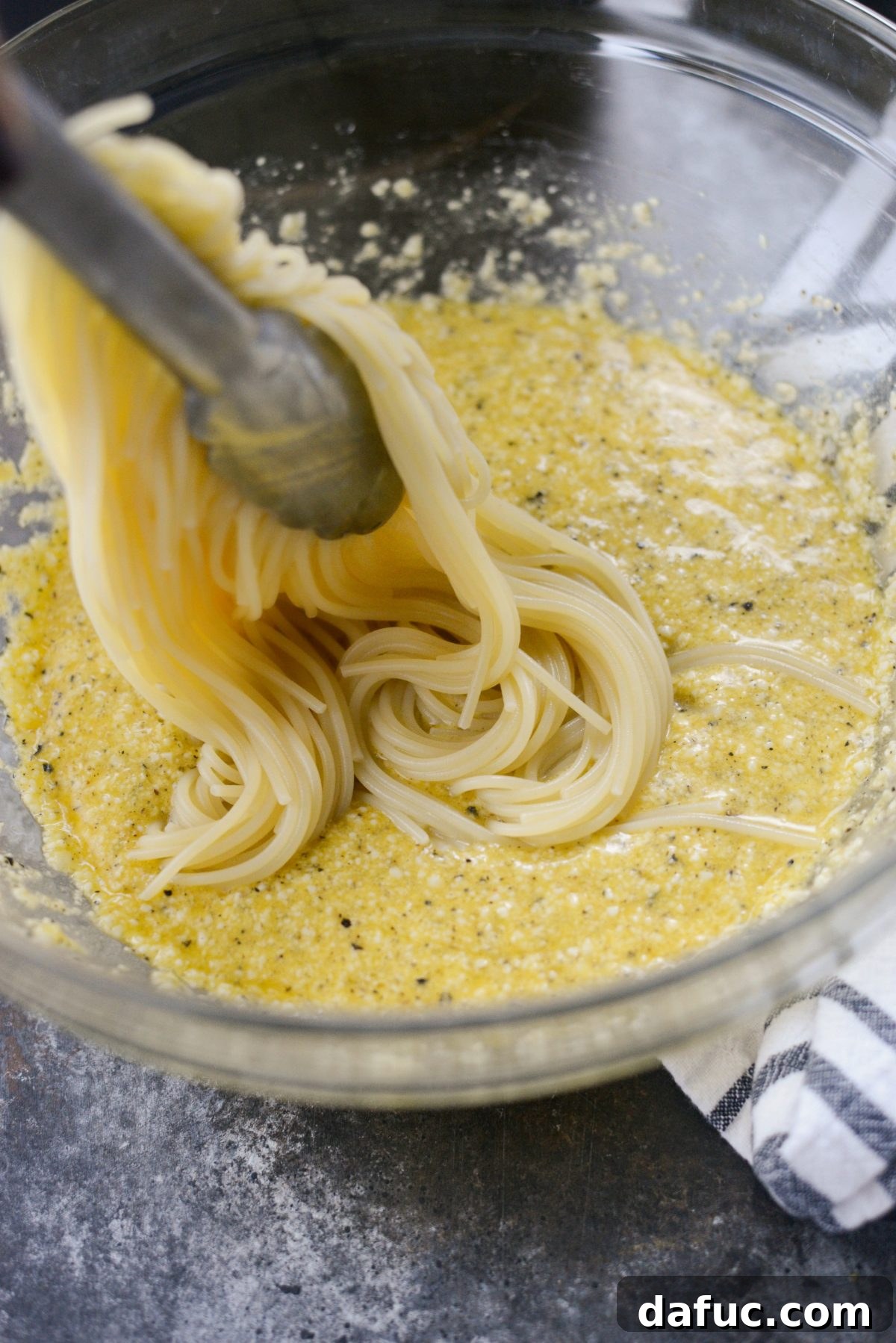 Reimagined Cacio e Pepe Carbonara 9 Adding hot spaghetti directly into the large bowl containing the egg, cheese, and pepper mixture.