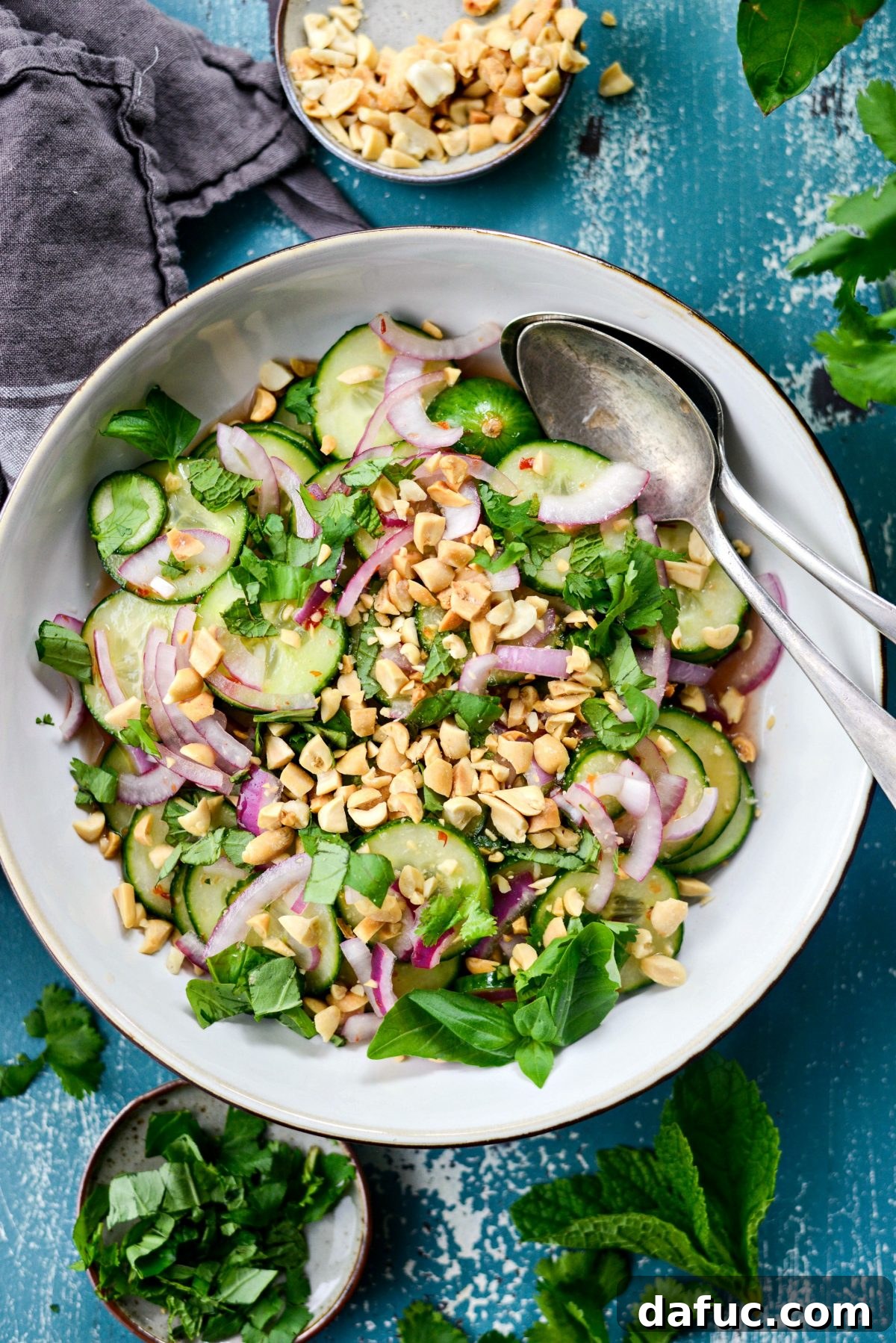 Thai Cucumber Salad Recipe, served in a bowl with fresh herbs and a serving spoon