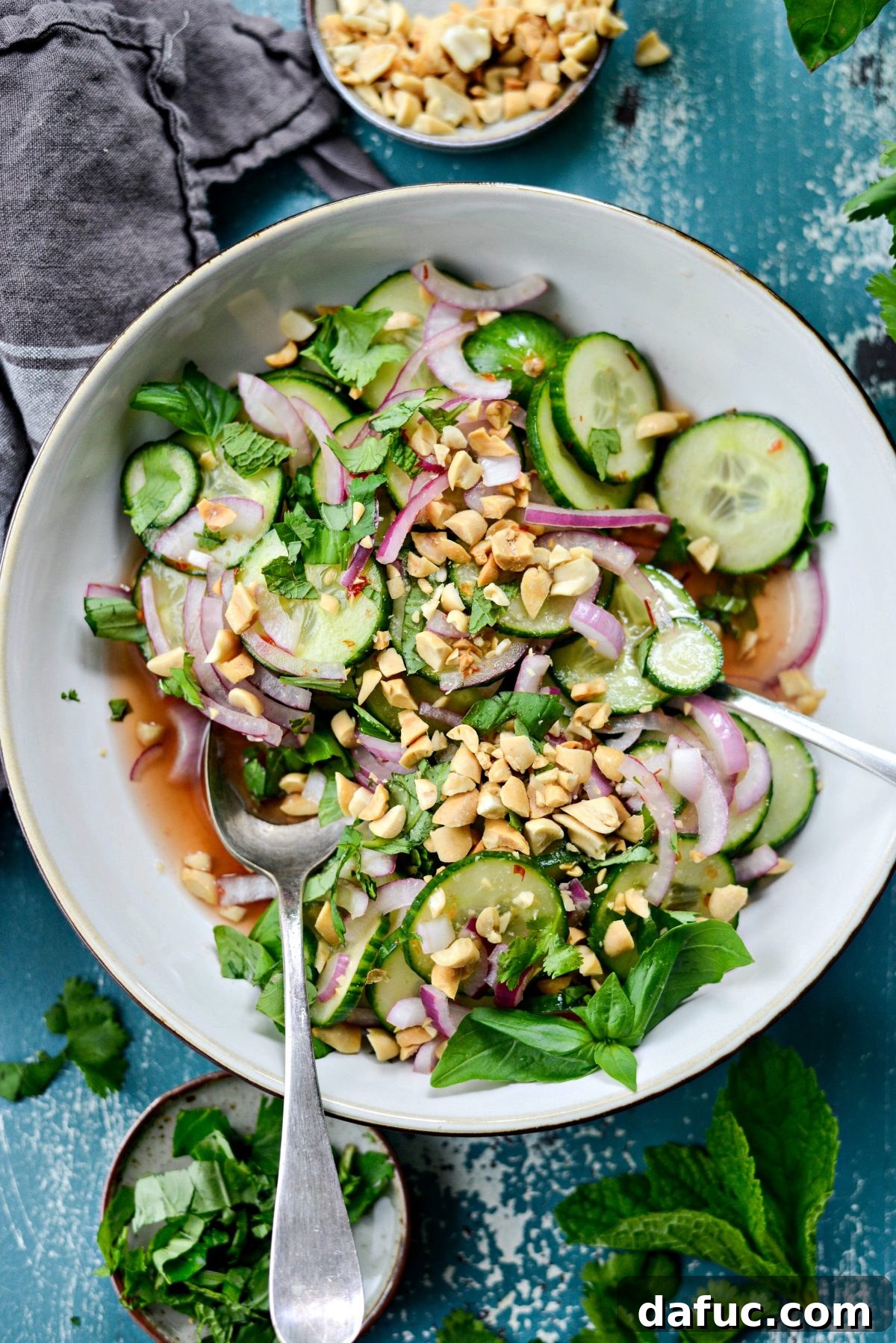 Thai Cucumber Salad served in a bowl with serving spoons, ready to be enjoyed