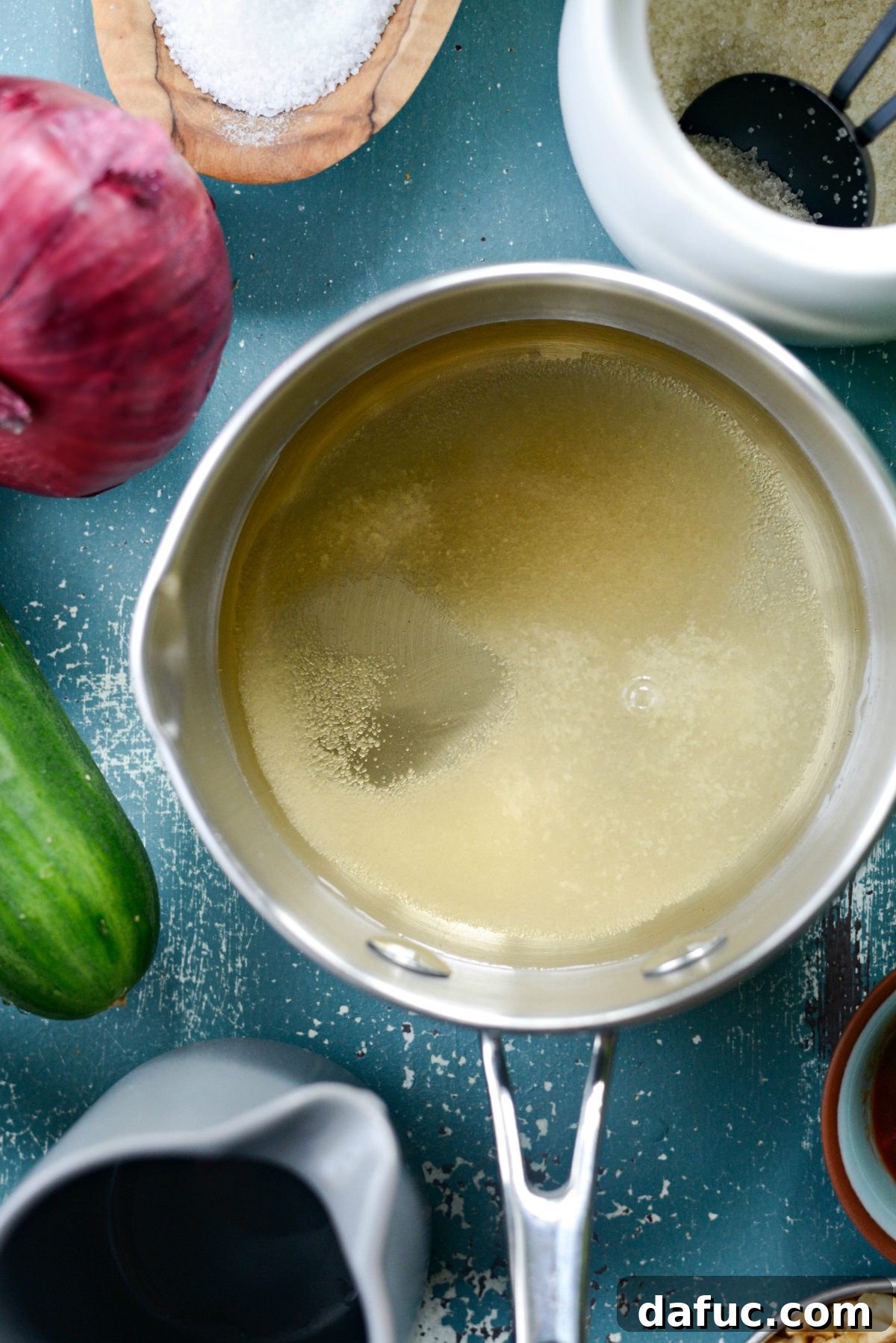 Pouring vinegar into the saucepan for the sweet and sour dressing