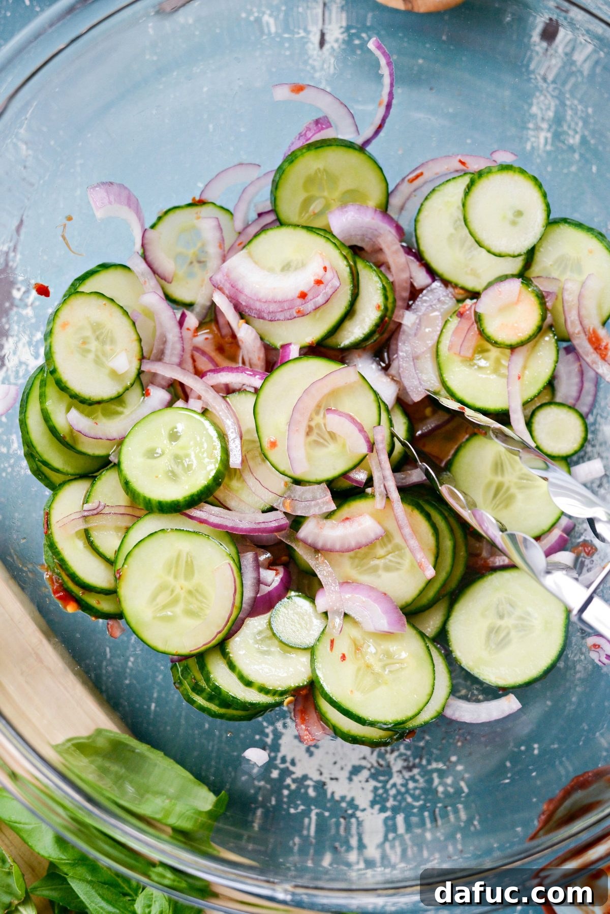 Tossing the cucumber and onion slices in the spicy vinegar syrup