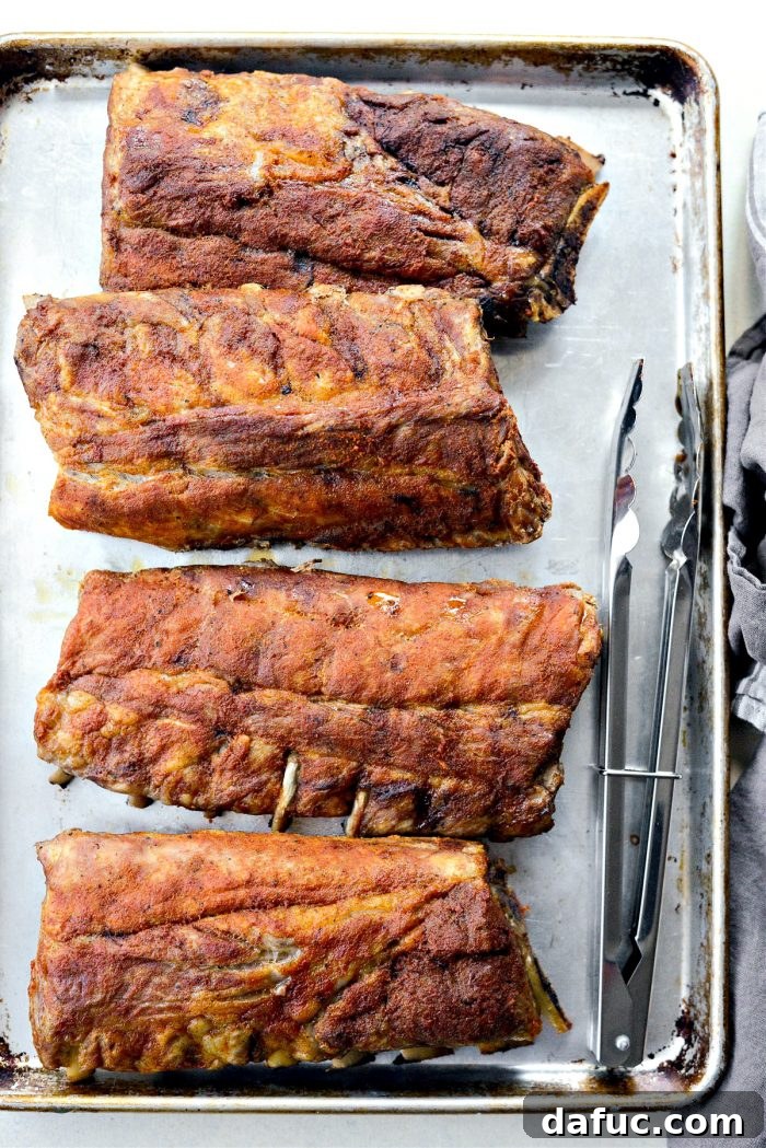 Unwrapped, tender oven-baked ribs on a baking sheet