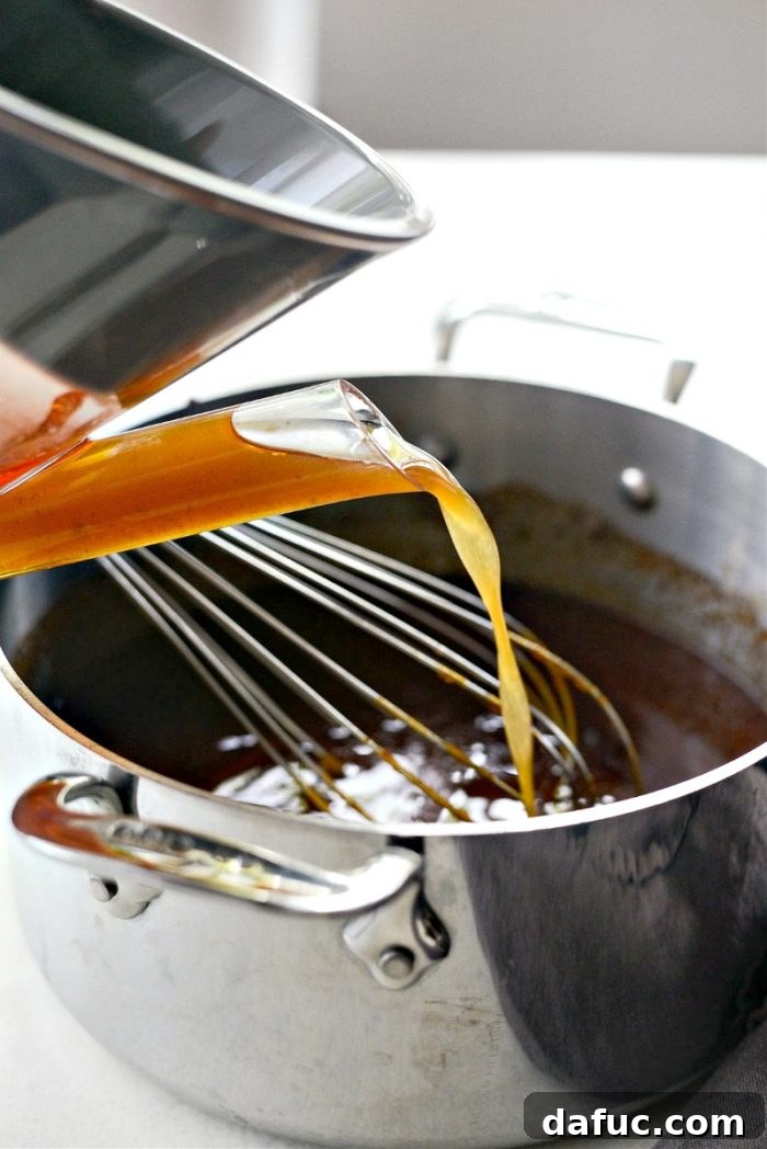 Adding reserved rib juices to the BBQ sauce, discarding fat