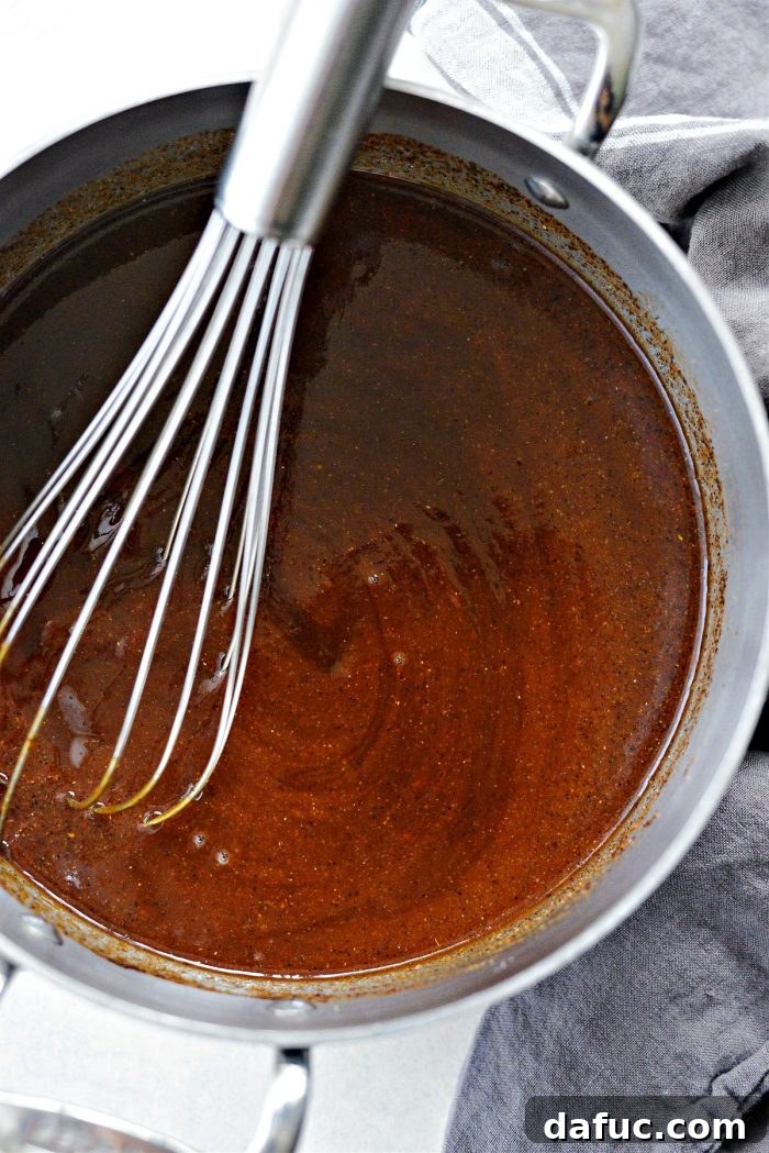 Stirring BBQ sauce ingredients in a pot on the stove