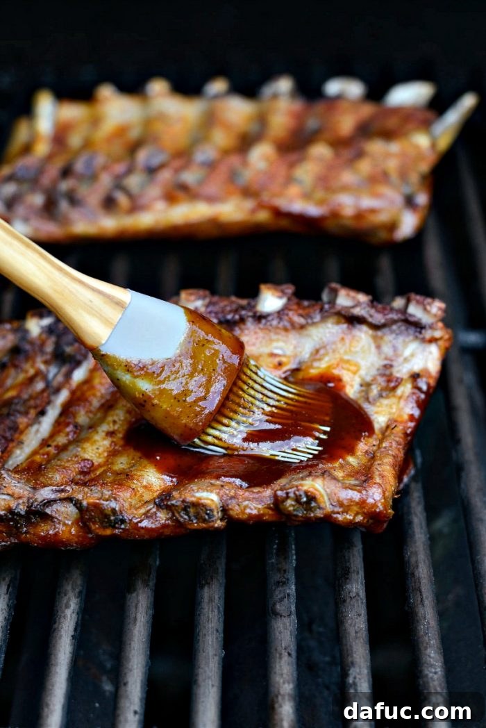 Grilling ribs, brushing with BBQ sauce on the grill