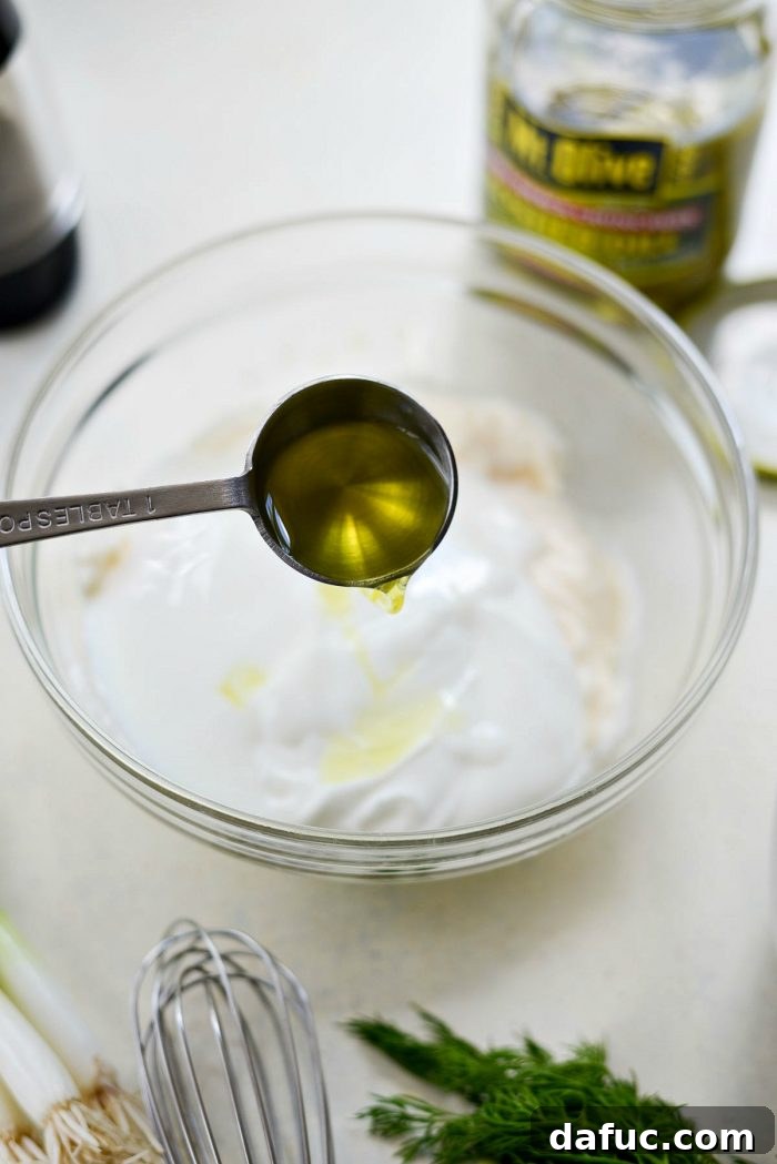 Pucker-Up Potato Salad 7 Ingredients for the potato salad dressing – yogurt, mayonnaise, and buttermilk – being combined in a bowl.