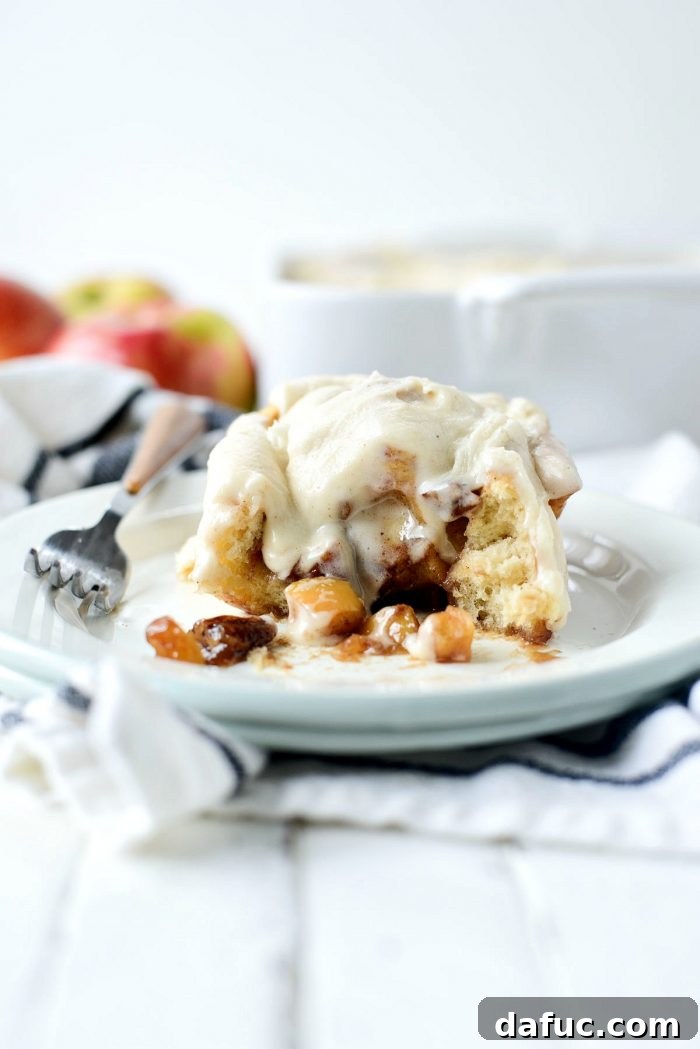 Close-up of baked Apple Pecan Chai Cinnamon Rolls, showing the rich filling and tender dough. SimplyScratch.com