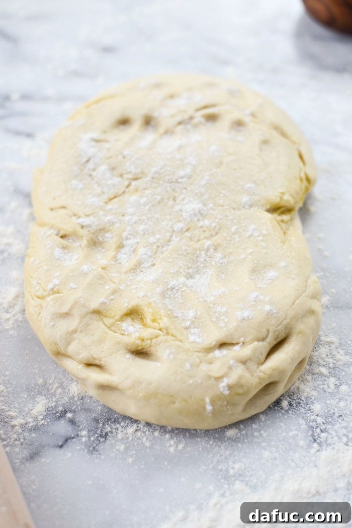 Ingredients for assembling cinnamon rolls, including risen dough and filling.