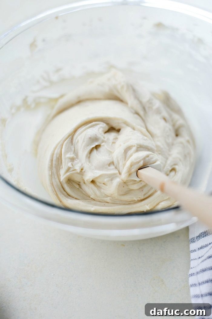 Adding powdered sugar to the icing mixture.