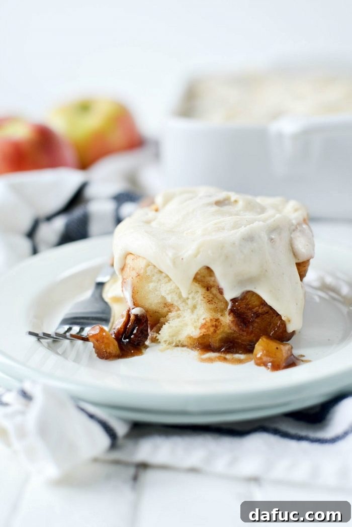 A delicious bite of Apple Pecan Chai Cinnamon Roll being pulled apart. SimplyScratch.com