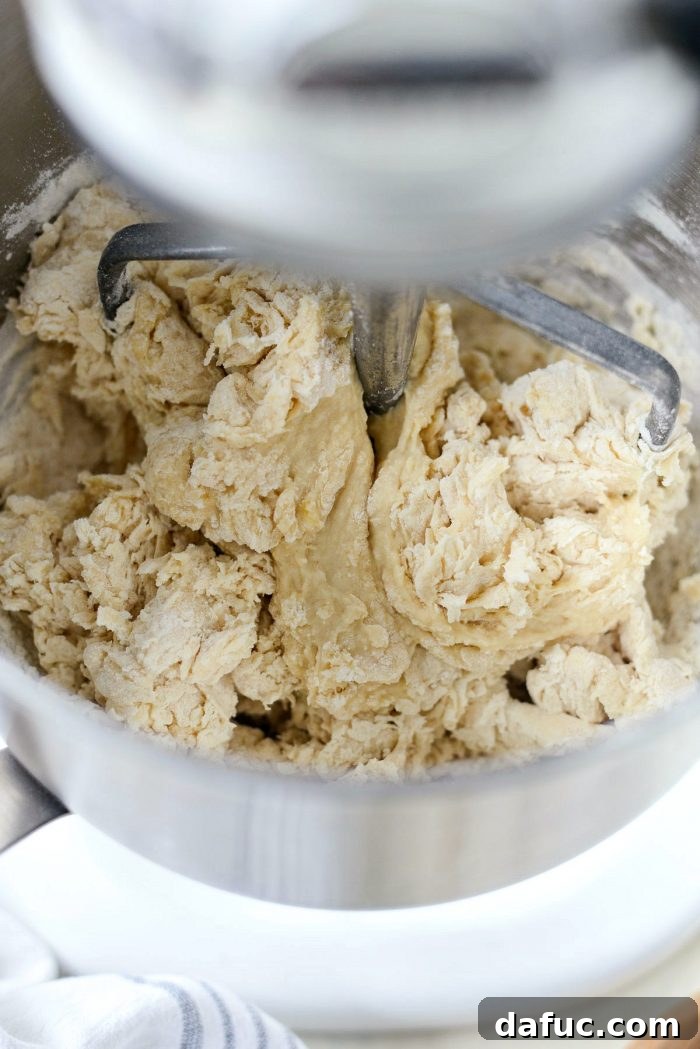 Adding flour and yeast mixture to the stand mixer.