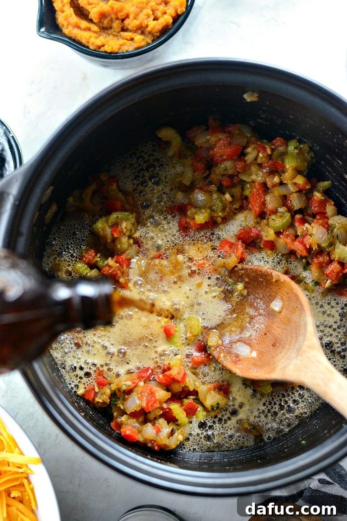 Harvest Ale & Creamy Cheddar Pumpkin Soup 12 Pouring a bottle of lager beer into the pot with the roux, stirring to create the soup base.