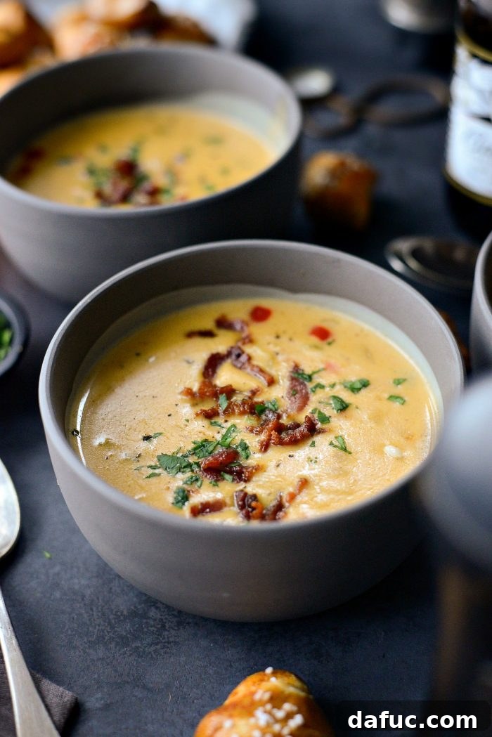 Harvest Ale & Creamy Cheddar Pumpkin Soup 18 Pumpkin Beer Cheese Soup served in a bowl, topped with crispy bacon and fresh parsley, a perfect fall meal.