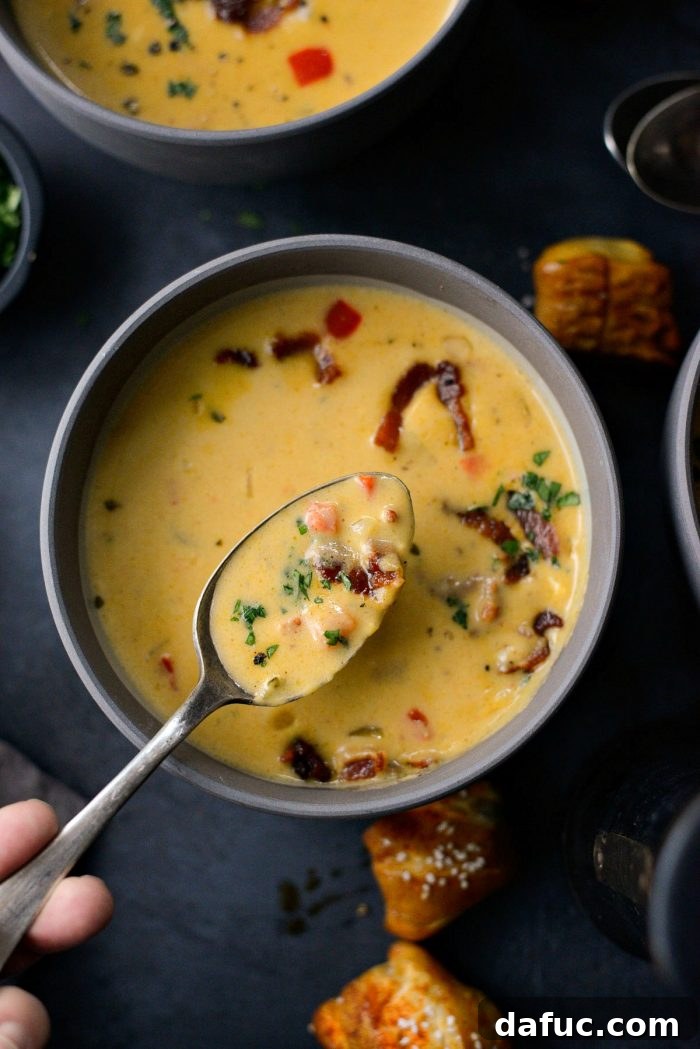 Harvest Ale & Creamy Cheddar Pumpkin Soup 20 Pumpkin Beer Cheese Soup in a bowl, a comforting fall recipe ideal for easy weeknight dinners or cozy gatherings.