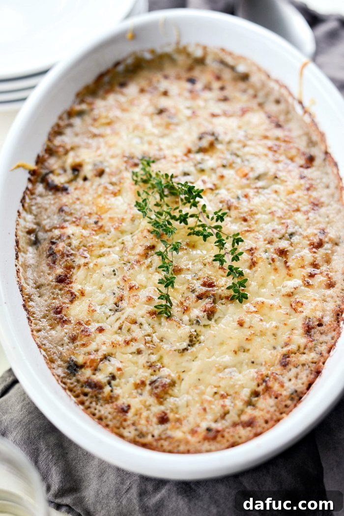 Hearty Mushroom Wild Rice Bake 14 A serving spoon lifting a spoonful of the creamy Mushroom Wild Rice Casserole.