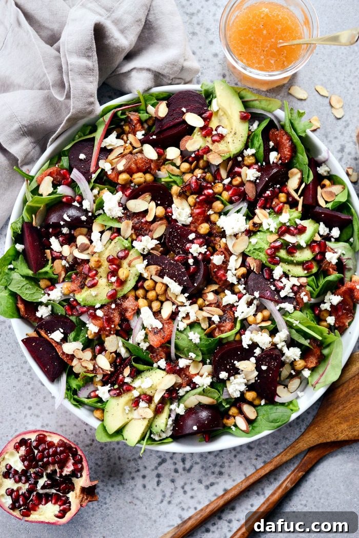 Serving bowl filled with power greens, roasted beets, grapefruit, and chickpeas, ready for dressing.