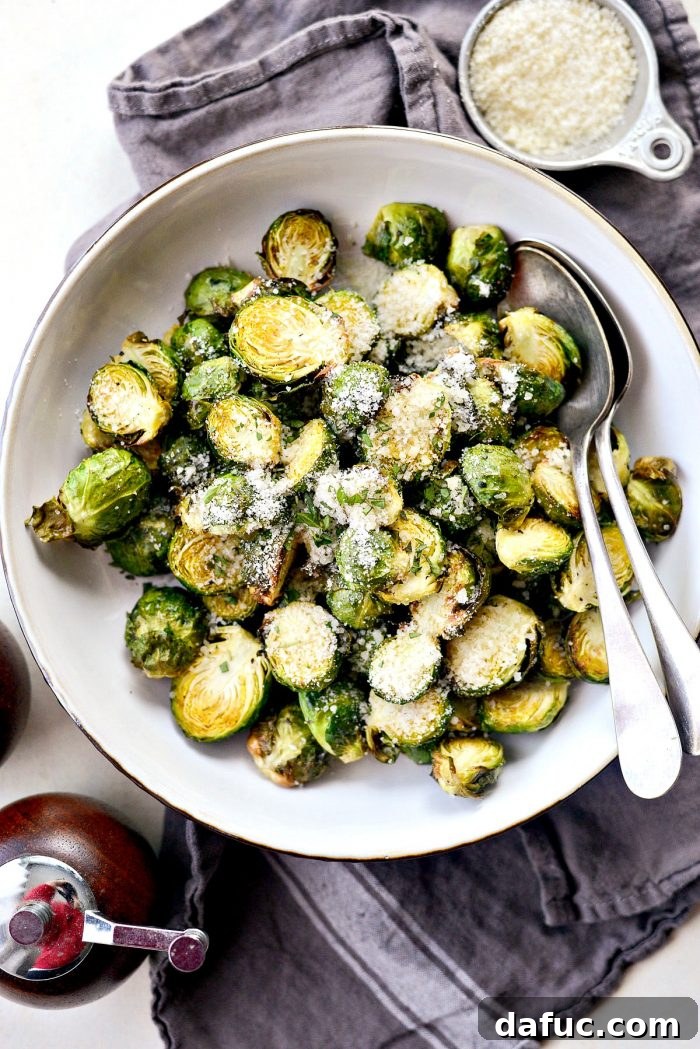 Crispy Air Fryer Brussels Sprouts served on a plate with Parmesan cheese.