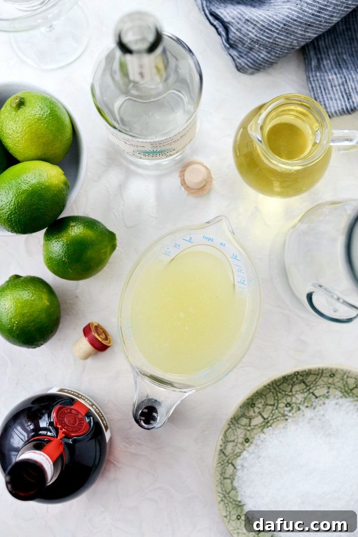 Signature Beergarita 5 A selection of fresh limes, a bottle of silver tequila, and orange liqueur laid out for making Beergaritas.