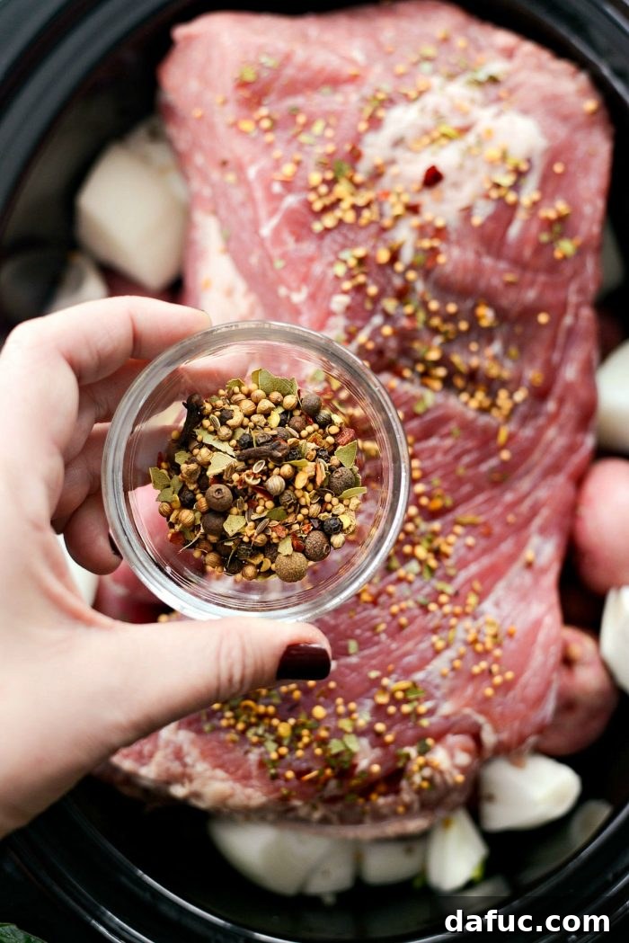 Effortless Slow Cooker Corned Beef and Cabbage 7 Adding seasoning packet and pickling spices to corned beef in slow cooker