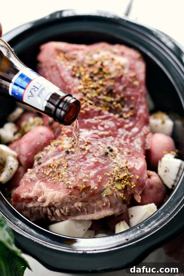 Effortless Slow Cooker Corned Beef and Cabbage 8 Pouring light beer into a slow cooker with corned beef and vegetables