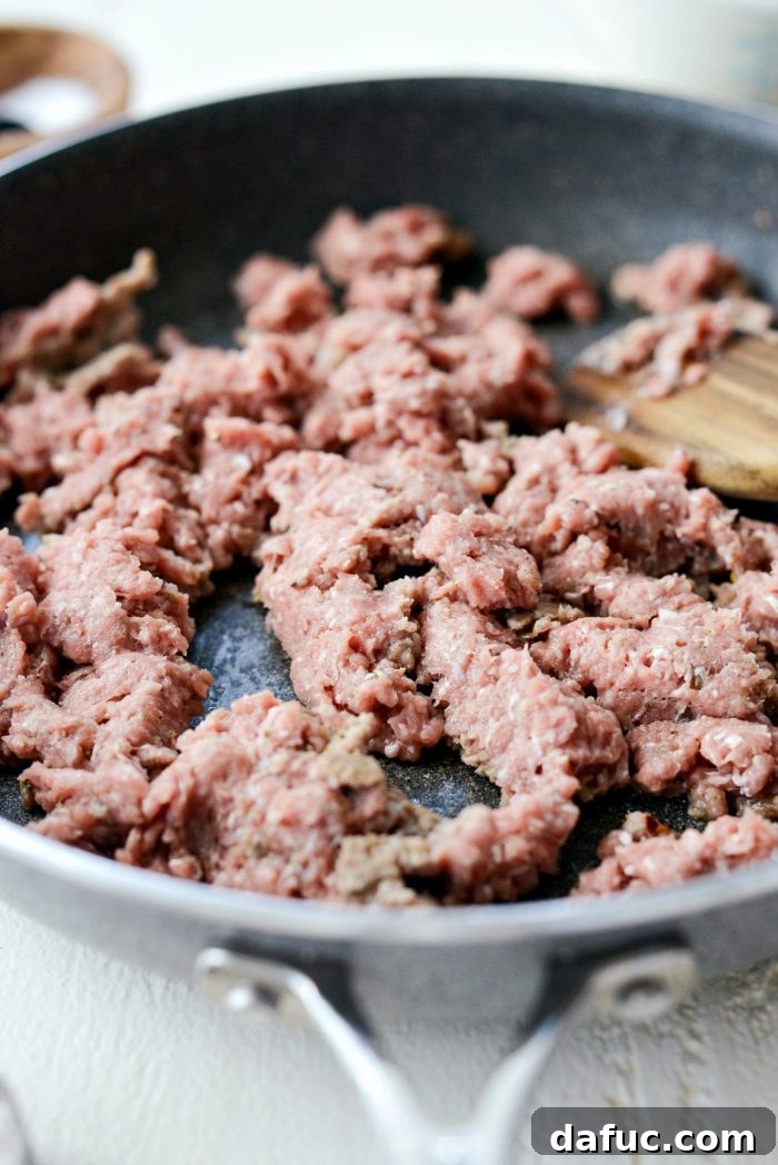 Cooked ground turkey sausage in a skillet, nicely browned and crumbled, ready for the next step of making gravy.