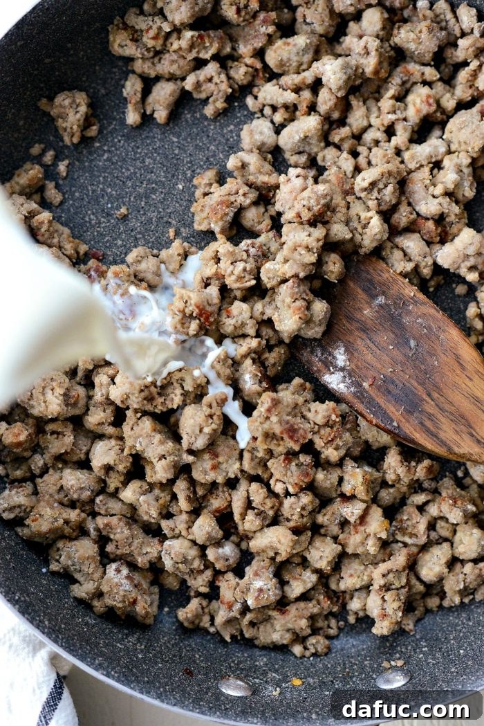 Flour fully absorbed into the turkey sausage, forming a base for the gravy in the skillet.