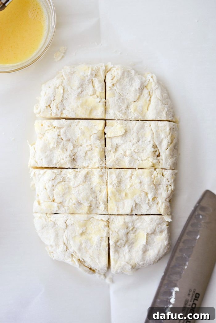 Cloud-Like Greek Yogurt Biscuits 11 Dough shaped into a rectangle on parchment paper, ready for cutting.