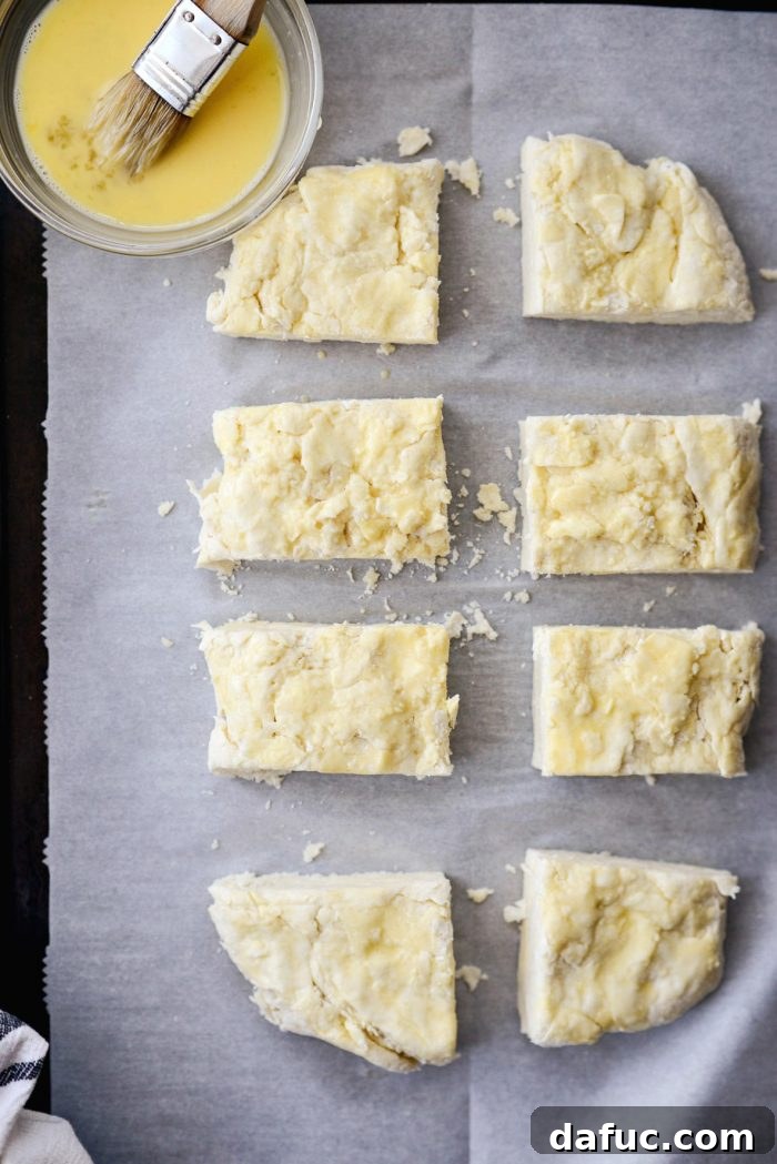 Cloud-Like Greek Yogurt Biscuits 12 The rectangular dough cut into 8 square biscuits on parchment paper.