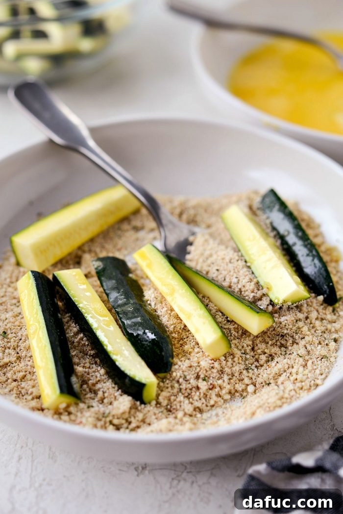 Crispy Air-Fried Zucchini Sticks 14 Zucchini fries being tossed in Parmesan breadcrumb mixture to coat.