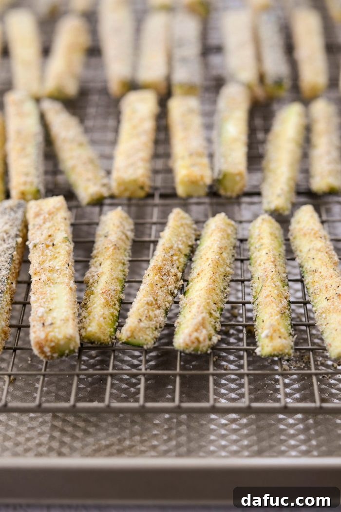 Crispy Air-Fried Zucchini Sticks 16 Coated zucchini fries arranged on a wire rack, awaiting air frying.