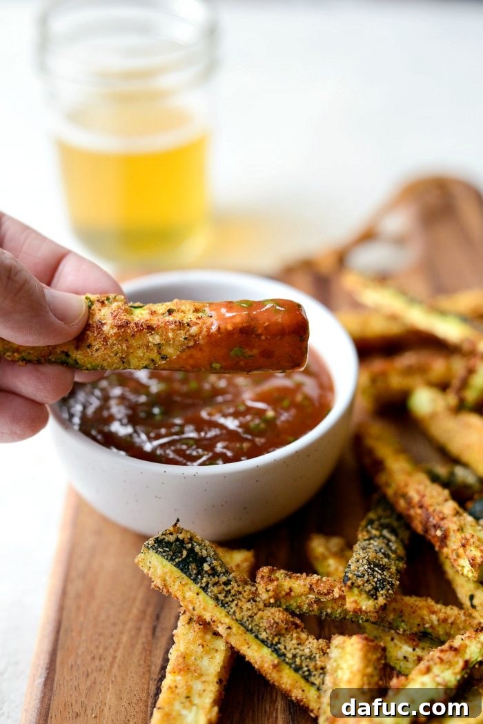 Crispy Air-Fried Zucchini Sticks 26 An air-fried zucchini fry coated in basil ketchup, ready for a bite.
