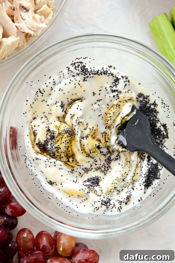 Zesty Greek Yogurt Chicken Salad with Sweet Grapes and Toasted Pecans 5 stirring salad dressing with black spatula.