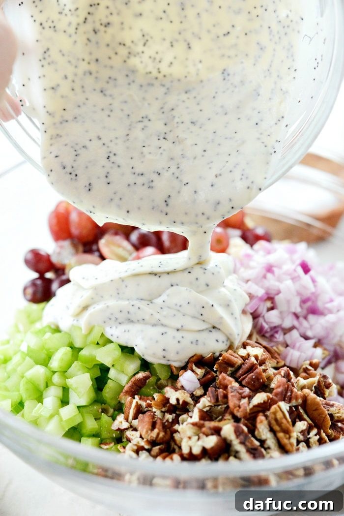Zesty Greek Yogurt Chicken Salad with Sweet Grapes and Toasted Pecans 8 pouring dressing into bowl with salad ingredients.