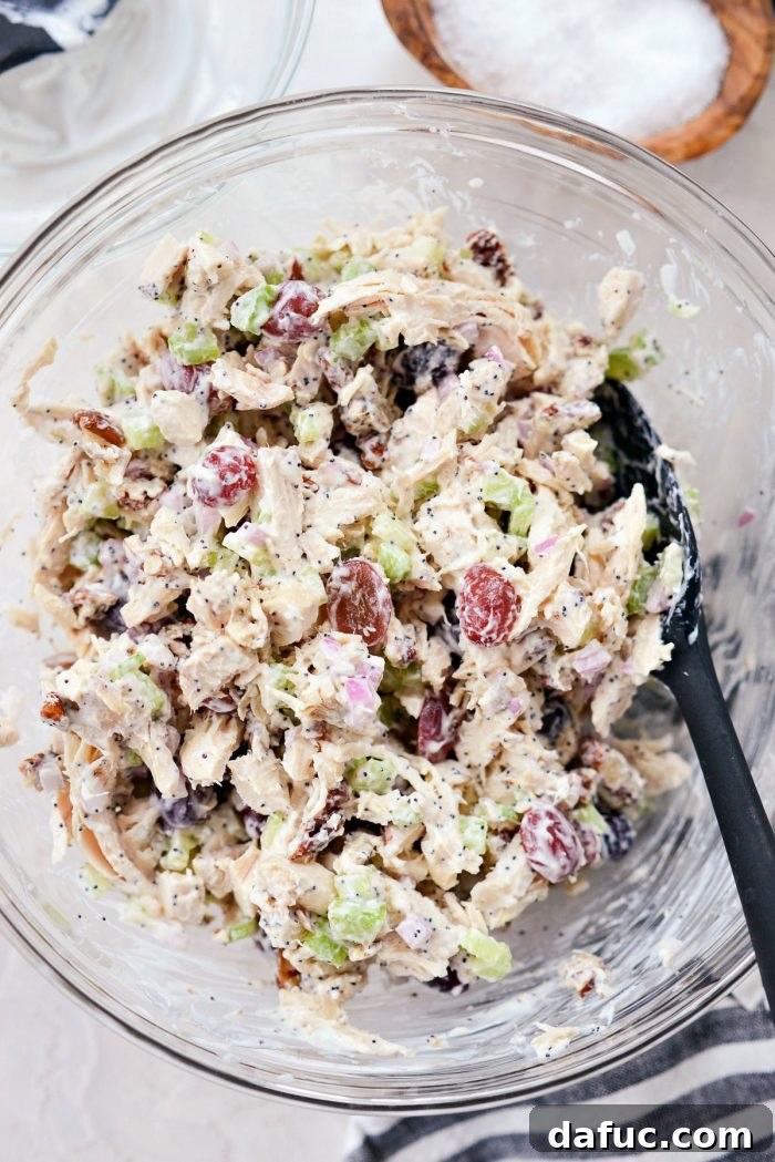 Zesty Greek Yogurt Chicken Salad with Sweet Grapes and Toasted Pecans 9 Salad mixed with dressing in clear bowl.