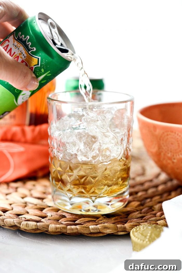 Lewis Peach Ginger Whiskey Infusion 8 Topping the peach whiskey and ice with ginger ale in a clear textured glass.