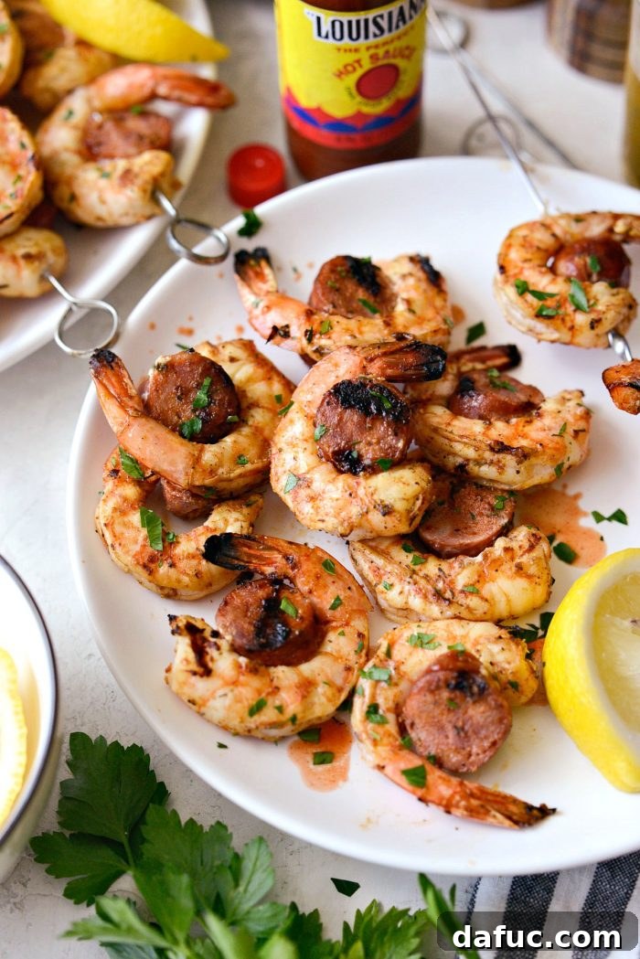 Close-up of Cajun Shrimp and Andouille Skewers removed from the skewer, resting on a white plate.