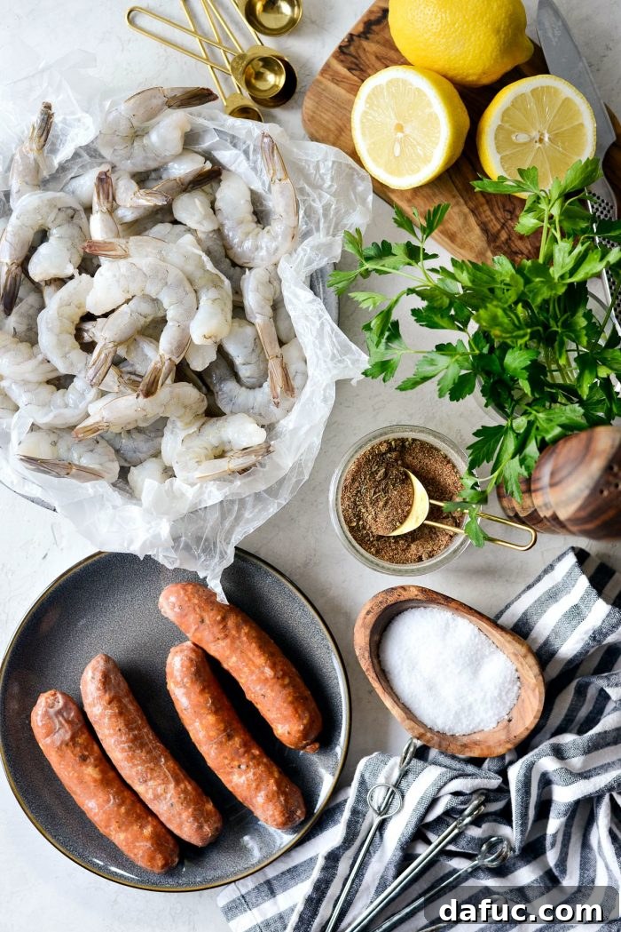 Fresh ingredients for Cajun Shrimp and Andouille Skewers, including jumbo shrimp, sliced andouille sausage, lemon, olive oil, and spices.