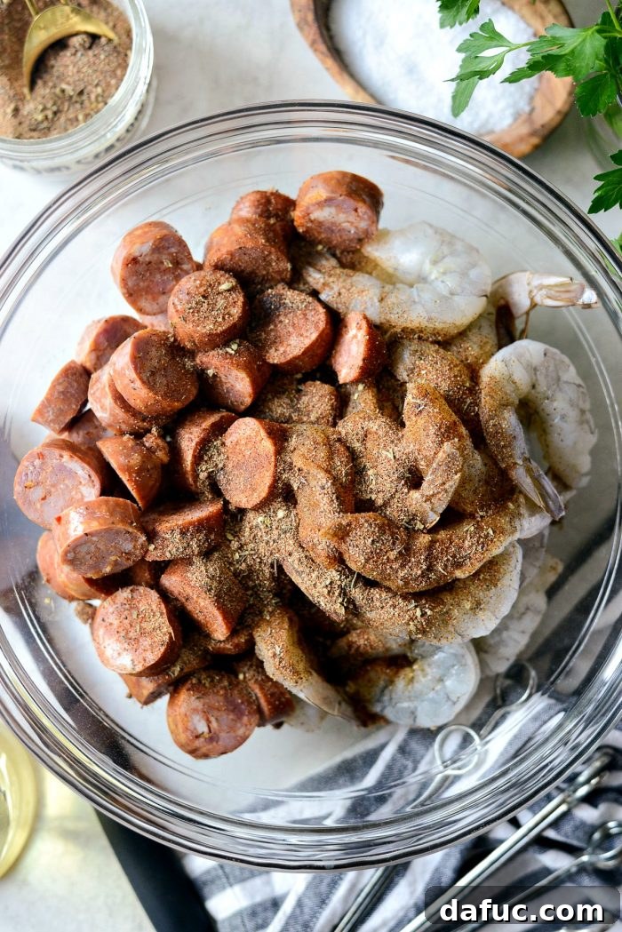 Jumbo shrimp, sliced andouille, olive oil, and homemade Cajun spice tossed together in a mixing bowl.