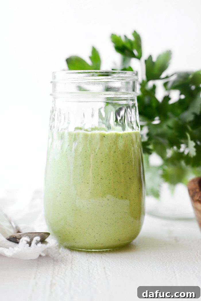 Pouring Green Goddess Dressing over a salad