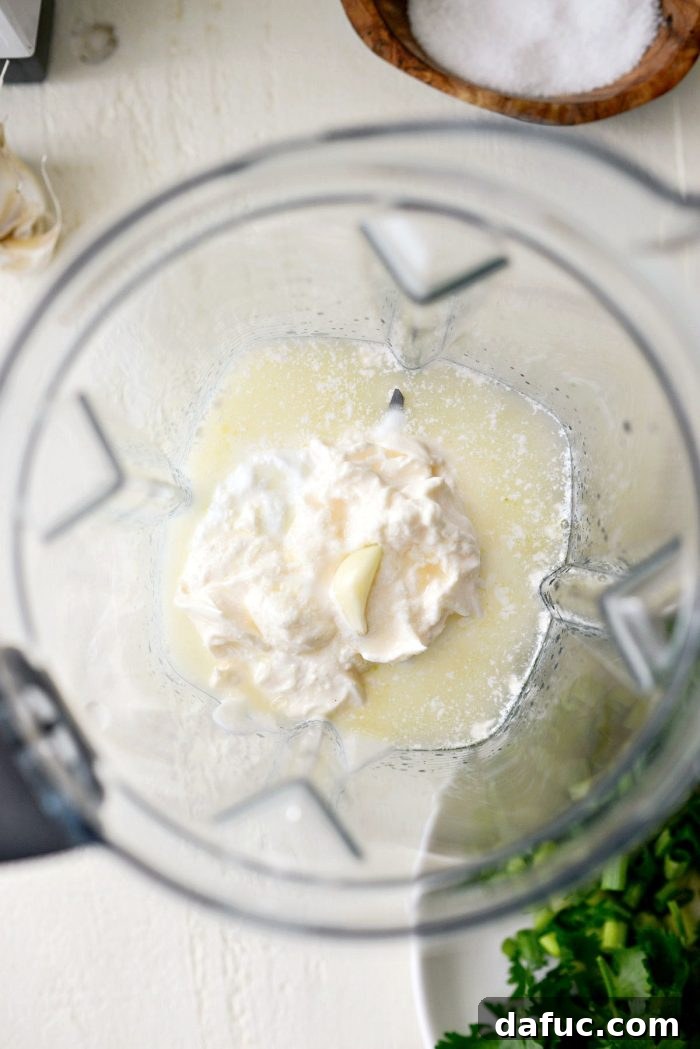 Garlic cloves and lemon juice being added to the blender