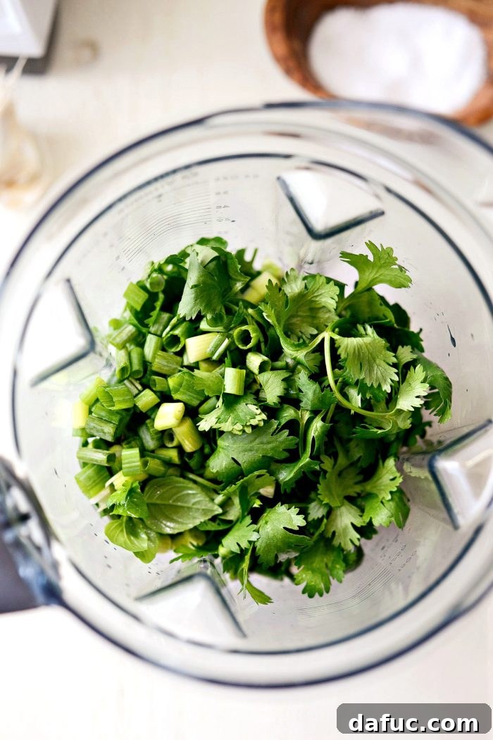 Fresh herbs and chopped green onions added to the blender
