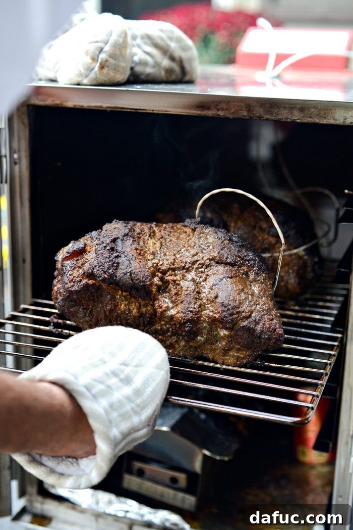 pulling out the rack with the smoked pork shoulder (butt).